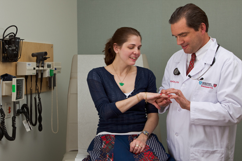 Doctor looking at a patient's hand Doctor looking at a patient's hand